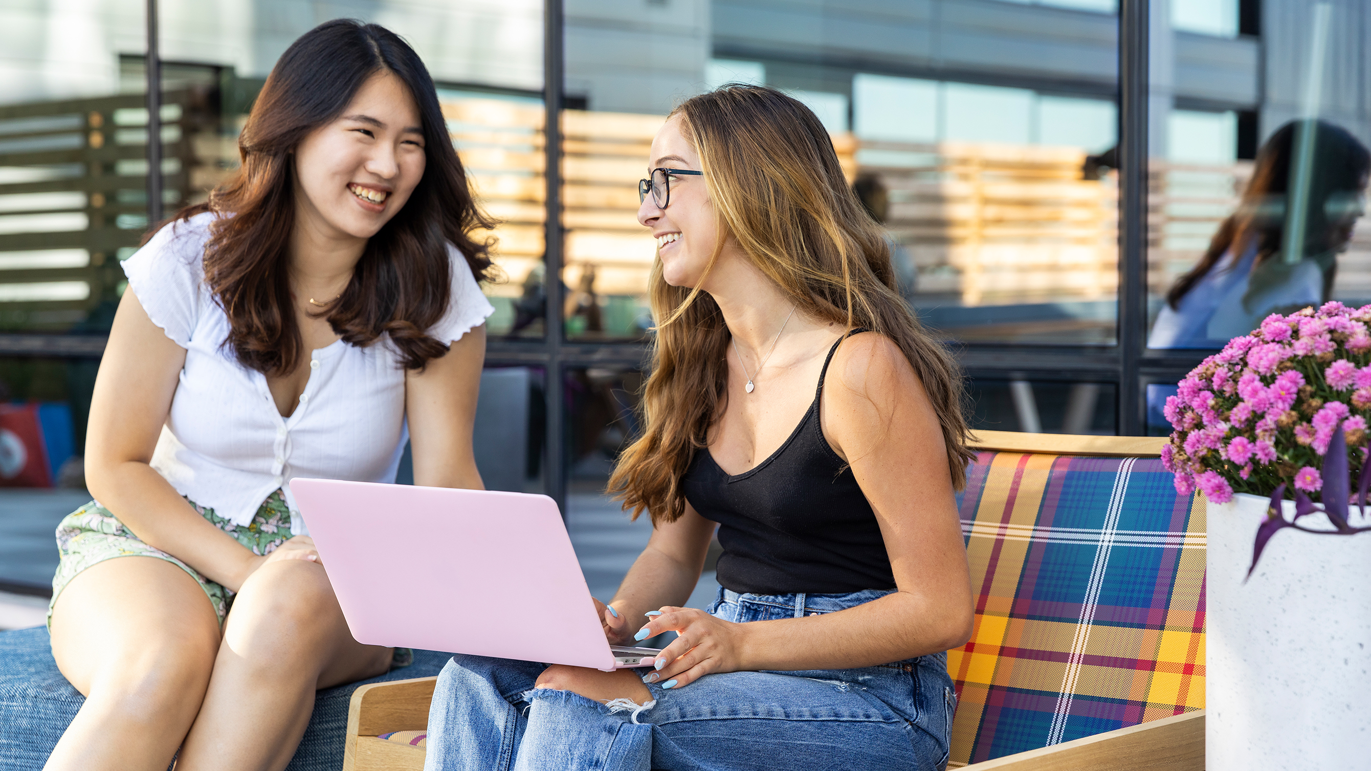 Two friends using a laptop