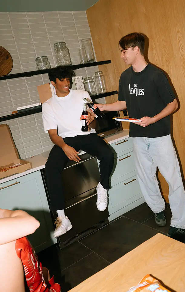 two men holding bottles of soda