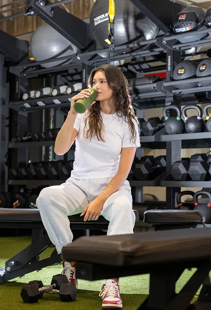 woman drinking water in a gym