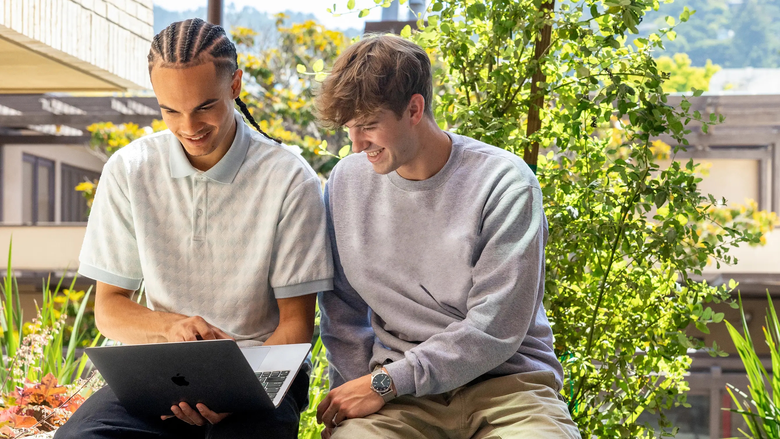 two men looking at a laptop